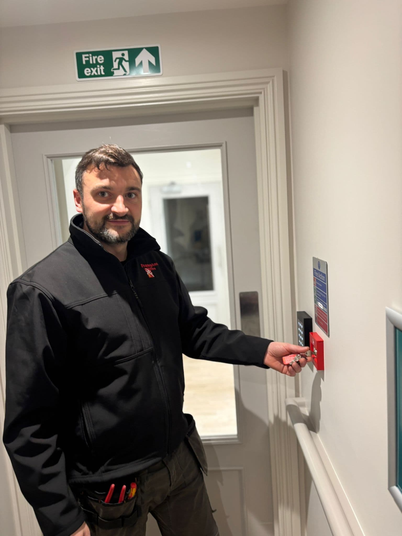 Engineer pressing button on fire panel
